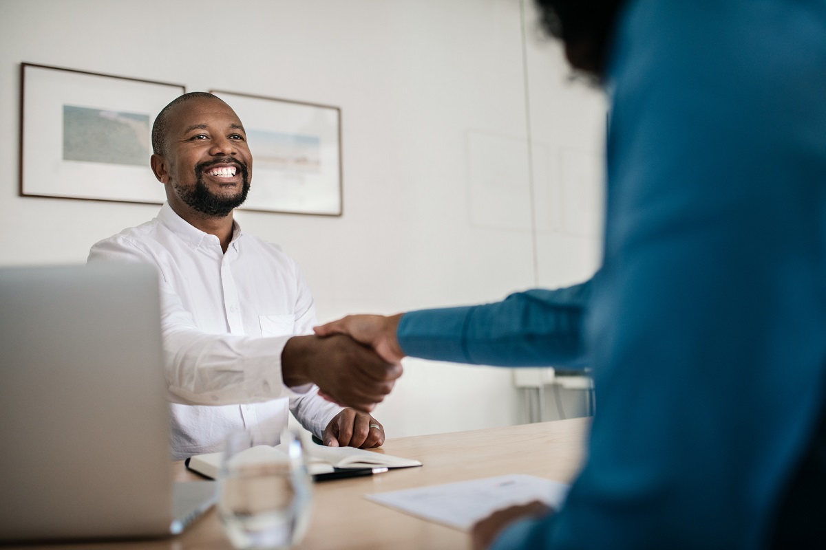 Smiling office manager shaking hands with a new employee