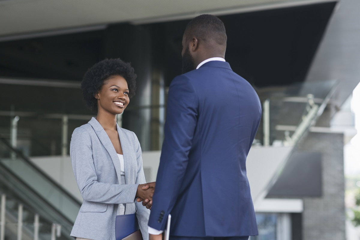 You're hired. Business people shaking hands near office building